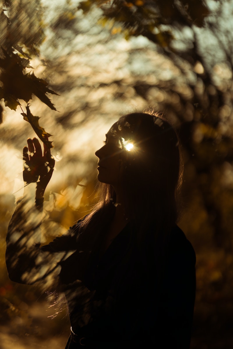 Photo by Masha Raymers Woman Touching Leaf